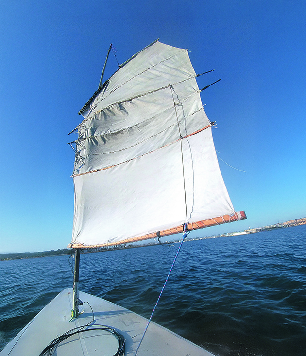 DIY sails being flown from a makeshift mast of a laser dinghy