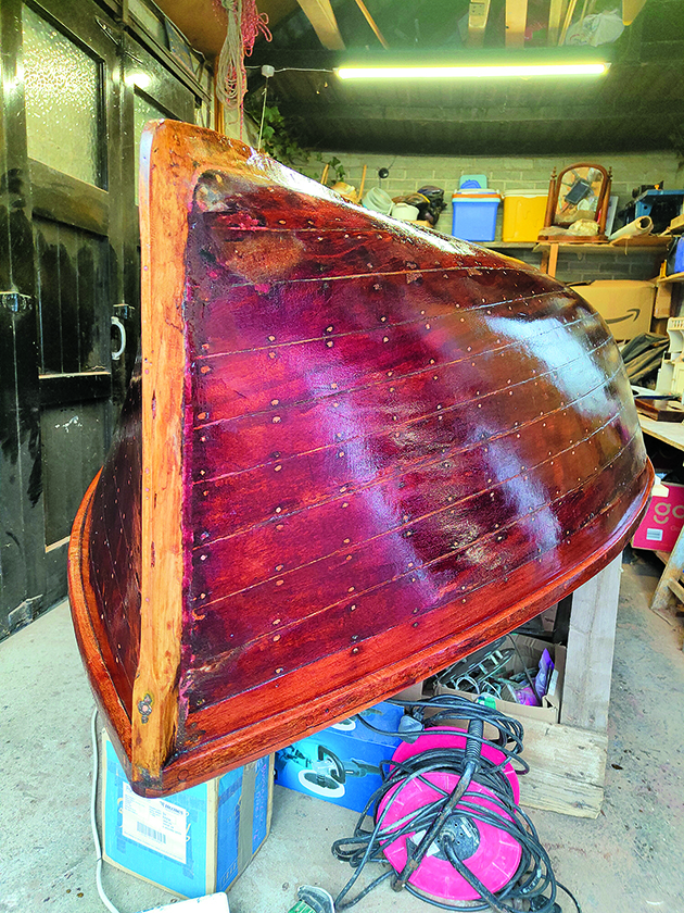 The upturned wooden hull of an International 14 dinghy