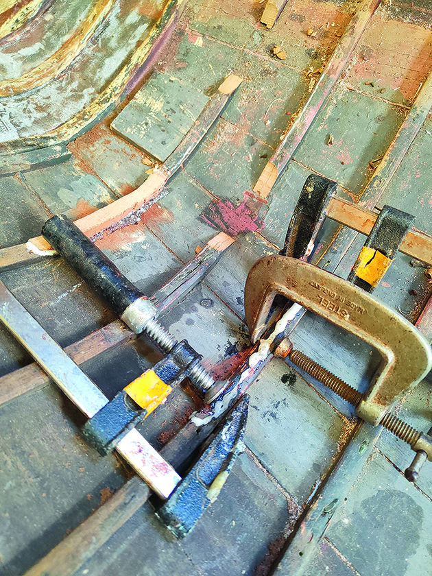 A clamp being used to hold an International 14 dinghy rib in place while it is being repaired