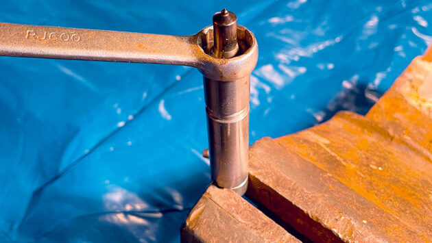 Spanners and a vice being used to loosen a nut