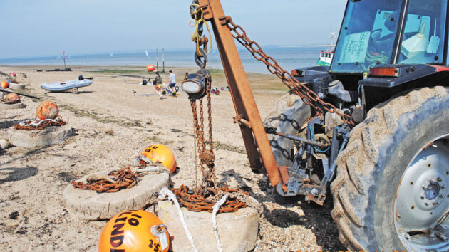 A tractor being used to move ground tackle for a mooring