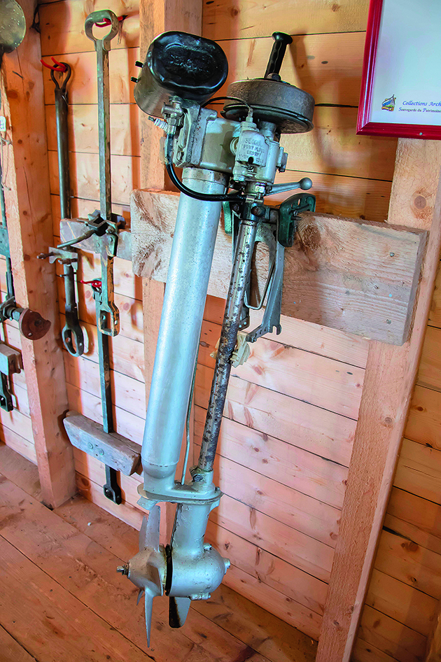 A British Seagull outboard leaning against the side of a shed