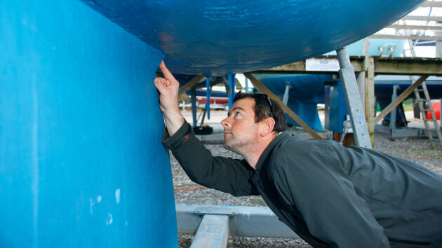 A man inspecting the keel of a boat