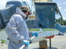 A man applying antifouling paint to a boat