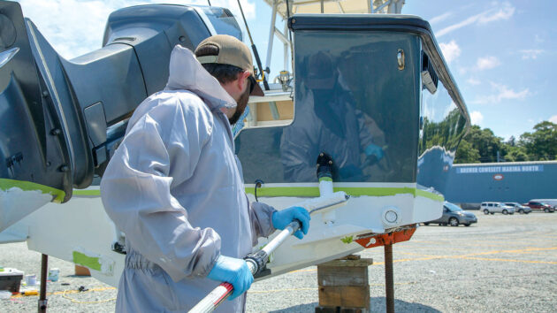 A man applying antifouling paint to a boat