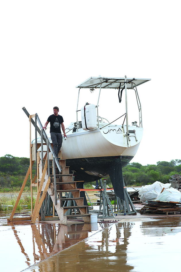 A man walking down steps by the side of an electric sailboat