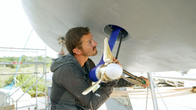 A man fitting a servoprop to make an all electric sailboat