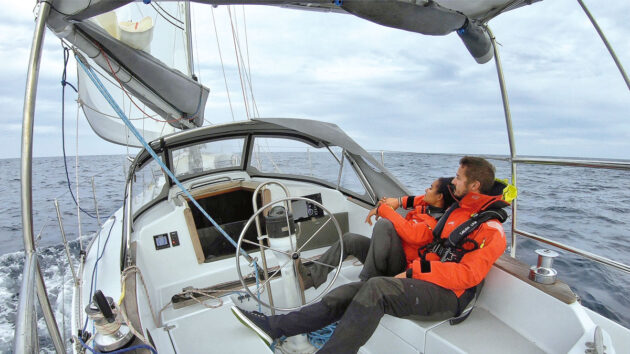 A couple sailing on an electric sailboat