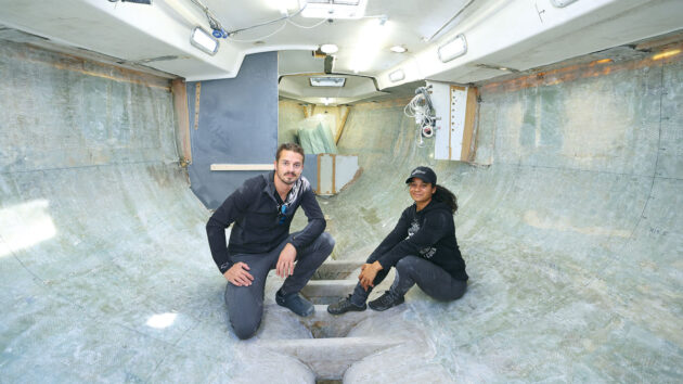 Two people working on their boat to make it a fully electric sailboat