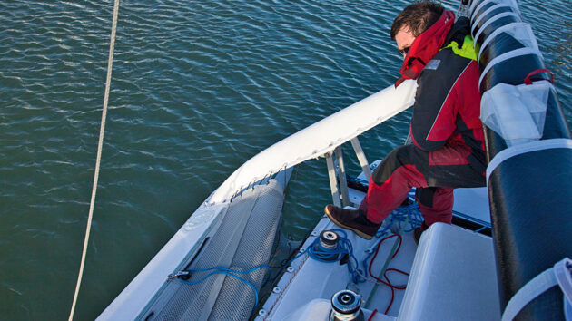A man folding floats on a trimaran boat