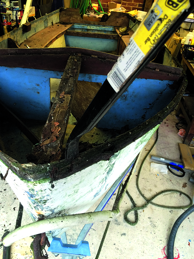 A demolition bar being used to remove broken parts of a dinghy before repairs