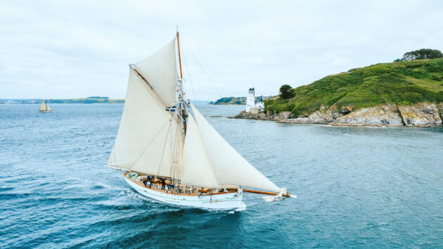 A large pilot cutter with white sails