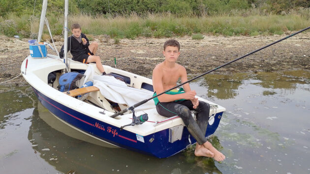 two boys fishing from a cruising dinghy