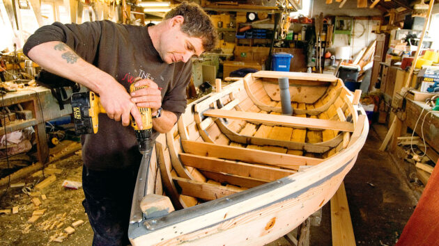 A man building a boat out of wood