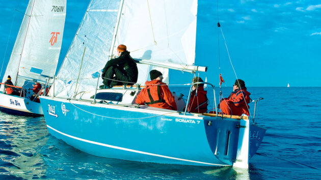 a yacht with a blue hull being sailed
