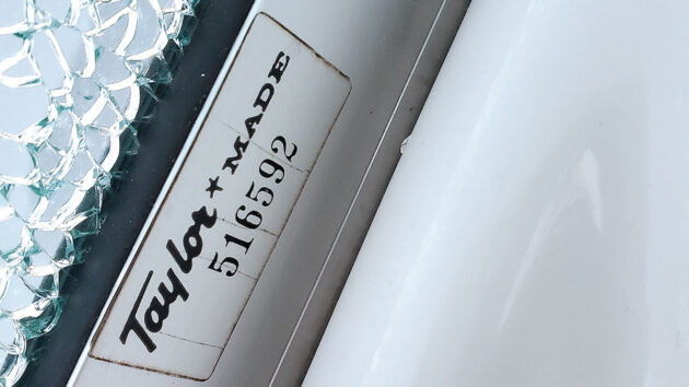 A serial number on the frame of a windscreen on a boat