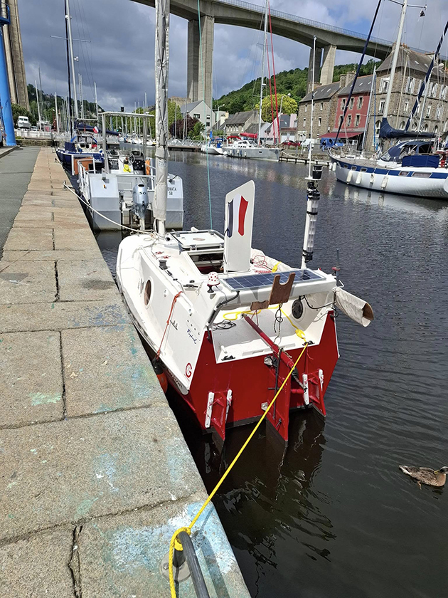 A small boat belonging to Yann Quenet moored by a pier