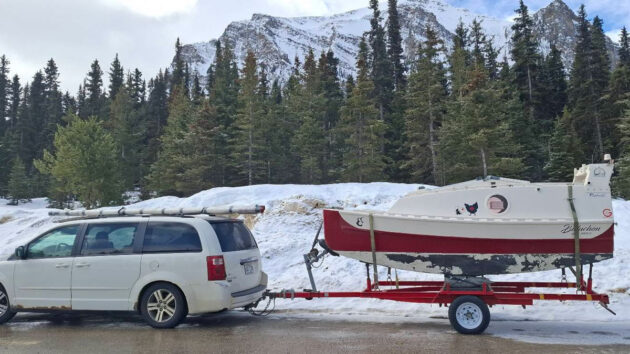 A 4m boat on a trailer behind a car