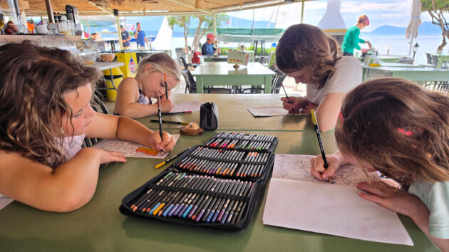 Four girls doing colouring in the taverna at Seafarer's Nikiana Beach Club, Greece. Credit: Jason Williams