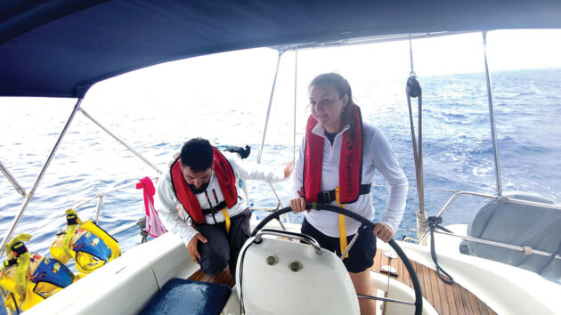 Laura Hodgetts at the helm of Bavaria 39 cruiser, Orestis charter yacht, on the Ionian Sea, during a Sail and Stay charter with Seafarer Holidays