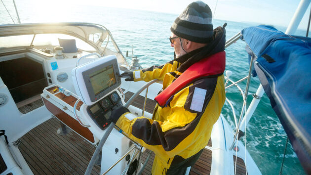 Man using an electronic chartplotter on a boat. Credit: Tyler Olson/Alamy