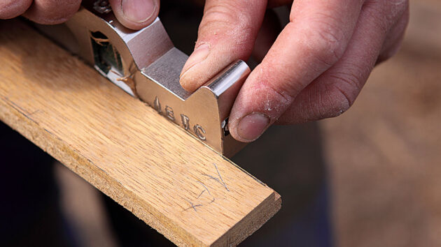A plane being used to trim a plank of teak wood