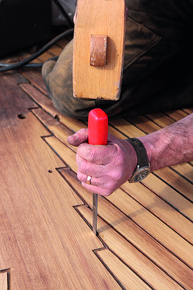 A man using a mallet and a screwdriver