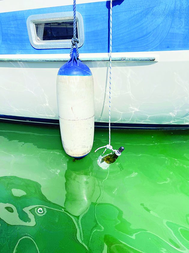 Wine being hung over the size of a yacht on a rope