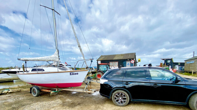 A car pulling a yacht on a trailer