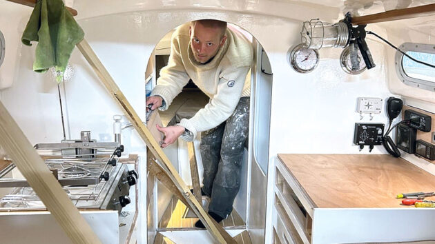 A man working on the interior of a Contessa 26 yacht