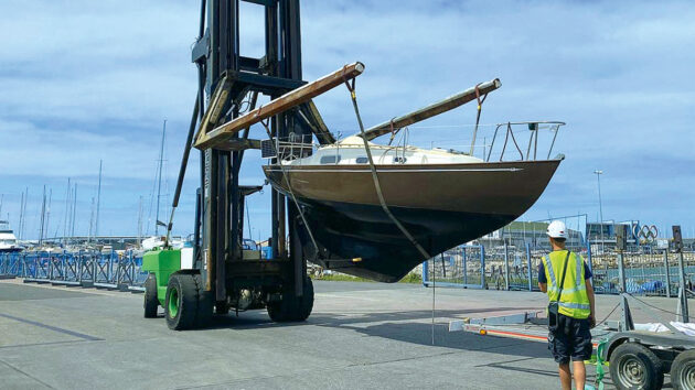 A Contessa 26 yacht on a lift waiting to be put back in the water