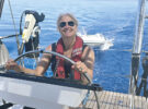 Smiling woman wearing a lifejacket at the helm of a yacht. Credit: Katy Stickland/Future Plc