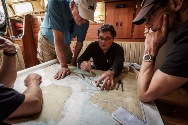 A captain and crew study the navigation charts to determine the sailing course in San Francisco, California. Credit: Pete Niesen/Alamy