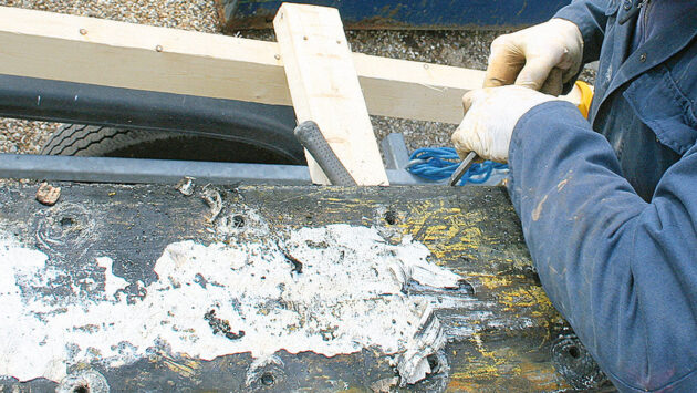 A man working on a keel and keel bolts on a yacht