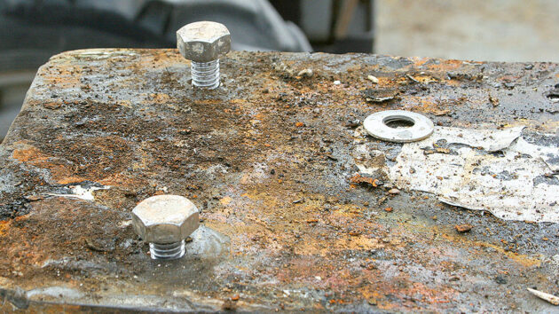 A man working on a keel and keel bolts on a yacht