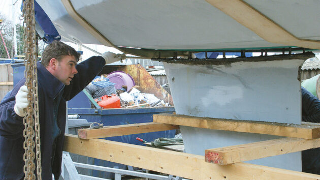 A yacht being lowered onto a keel with keel bolts alighned