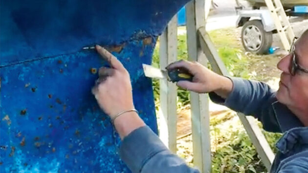 A surveyor checking the keel of a yacht