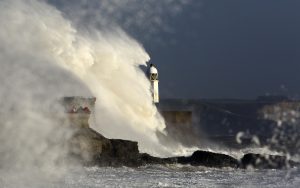 Waves hit a lighthouse during Storm Ophelia