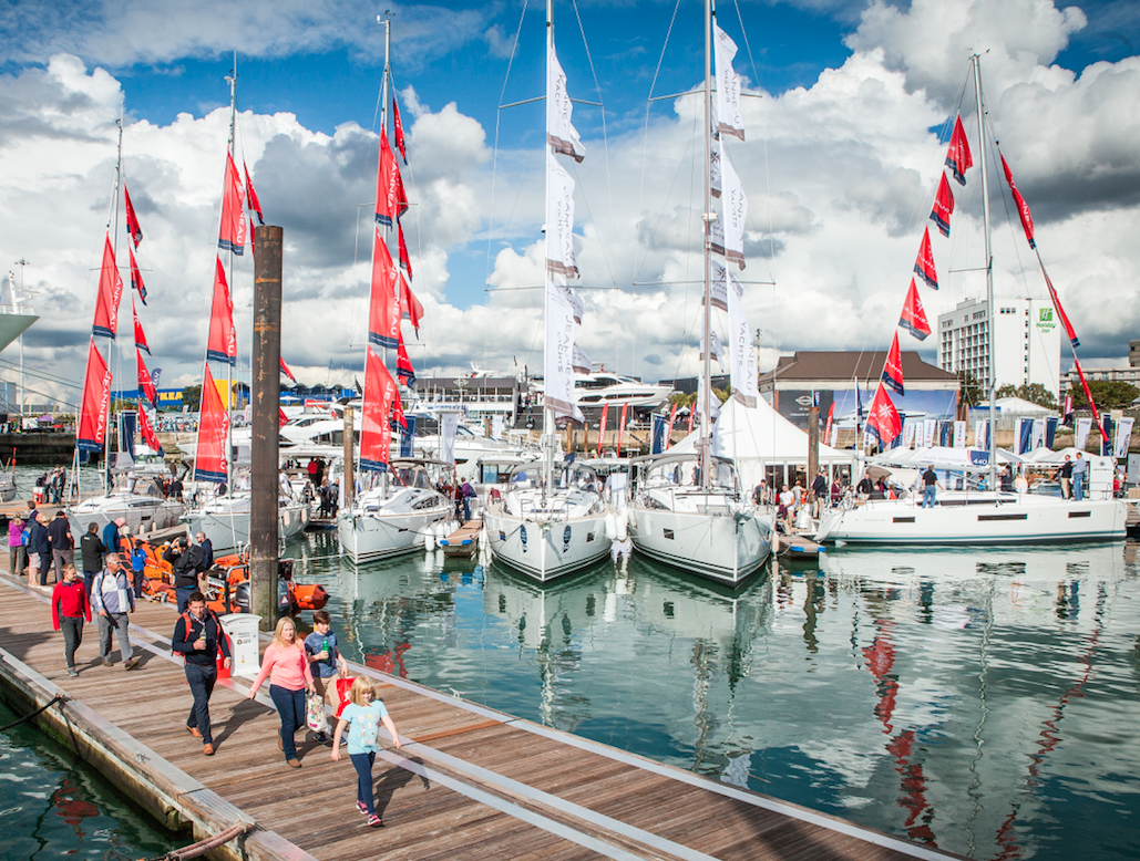 People walking on pontoons looks at boat at the Southampton Boat Show