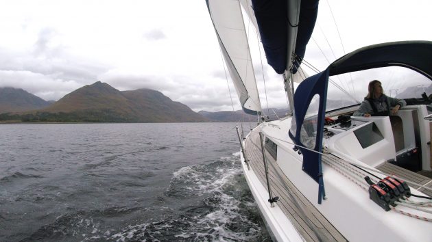 A yacht sailing in a loch in Torridon, Scotland