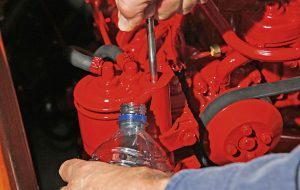 Oil is checked on a red boat engine - a necessary piece of maintenance before the end of the sailing season