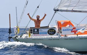 Mark Slats raises his arms as his rounds the first mark at Lanzarote during the Golden Globe Race