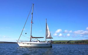 A white yacht a anchor under a blue sky and a calm sea