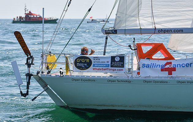 A skipper waves as he manoeuvres his yacht to the start line for the Golden Globe Race