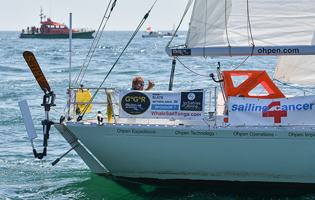 A skipper waves as he manoeuvres his yacht to the start line for the Golden Globe Race