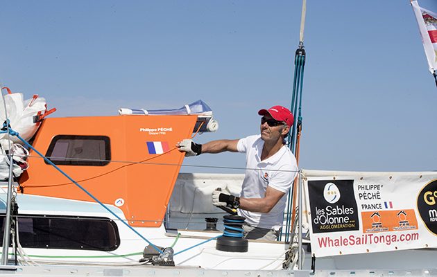 A Golden Globe Race skipper wearing a white tshirt and red hat