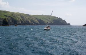 A yacht dragging its anchor in windy weather at Mullion Cove