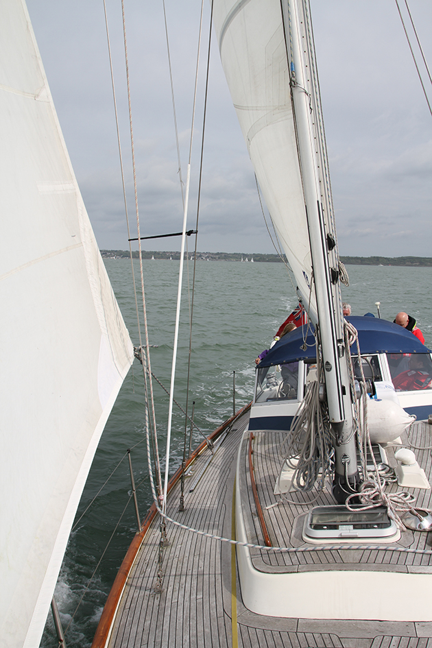 A yacht with a sail and wooden deck