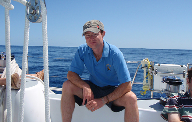 John Savage wearing a blue t-shirt