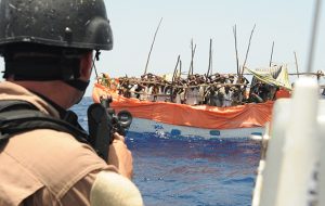 A soldier points his gun at suspected pirates in the southern Red Sea